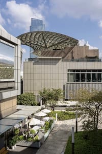 A modern building with a large dome on its roof, featuring a mix of concrete, glass, and metal materials, with a sophisticated and elegant atmosphere