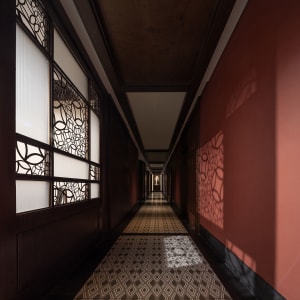 A long, wood-lined hallway with multiple windows on each side, creating a calm and quiet atmosphere