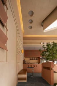 Dining area with beige walls, a table, chairs, and potted plants, in a modern and minimalistic style