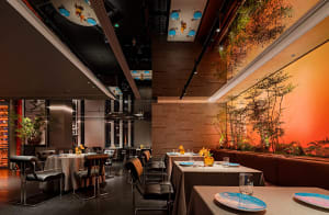 Elegant dining area with a wooden table and chairs, wine glasses, and tableware, set in a warm and inviting atmosphere