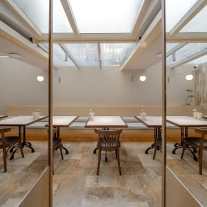 A modern restaurant interior with multiple tables and chairs, providing a comfortable atmosphere for guests to enjoy their meals