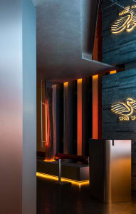 Commercial interior space with a stone wall, two sinks, and a refrigerator, featuring a modern design and well-designed layout