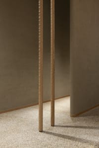 A dimly lit hallway with wooden walls featuring vertical panels and columns extending into the distance