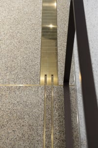 A modern metal staircase in a well-lit interior space with a sense of elegance and sophistication