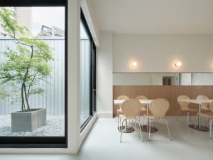 A modern dining area with a wooden table and several chairs, set in a contemporary restaurant atmosphere