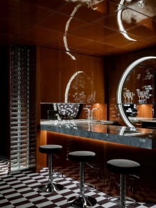 Modern kitchen with a large island, stools, sink, and wine glasses, giving off a sophisticated vibe
