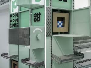 A modern living space with a green wall featuring various signs for room layout and organization