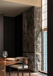 A dining table set for a meal with two chairs, a wine glass, and a cozy atmosphere