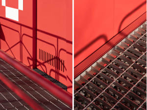 Image of a staircase with red walls and a metal railing, possibly a building's exterior with a concrete structure