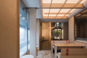 Dimly lit restaurant with wooden walls, floors, and furniture, creating a cozy atmosphere with a modern style