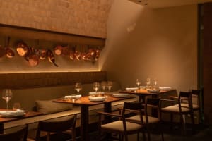 Elegant dining space with multiple tables and chairs, set with wine glasses and cups, creating an inviting atmosphere for fine dining