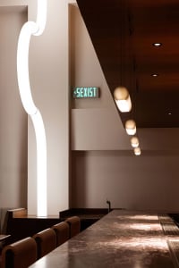 A modern dining space with white walls, illuminated by ceiling lights, and a comfortable atmosphere