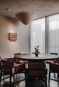 A dining area with a round wooden table surrounded by chairs, creating a cozy atmosphere for gatherings and meals