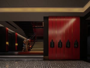 A busy public space with red walls, black doors, and people scattered throughout the area