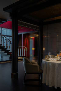 Dining area with a table set for dinner, red walls, and comfortable seating