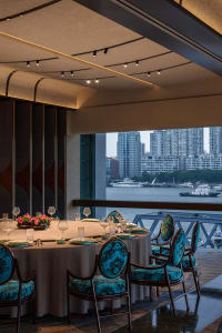 Elegant dining space with wooden furniture, tables set with plates and wine glasses, and comfortable seating for guests