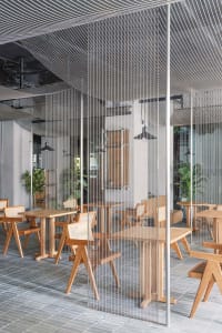 Modern restaurant interior with wooden tables and chairs, warm atmosphere, and comfortable seating for guests