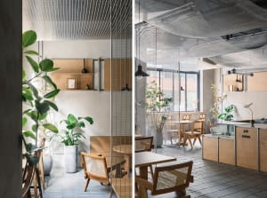 Modern restaurant interior with wood flooring, glass walls, and natural light, featuring a dining area, bar, and potted plants