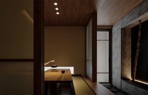 A dimly lit dining room with a wooden table surrounded by chairs and two people, a bowl on the table suggests a meal is being shared