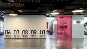 A clean and organized office space with a large white wall displaying numbers in black, surrounded by chairs and a minimalist atmosphere