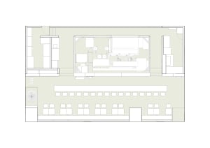 Empty modern office space with white walls and floors, featuring scattered chairs and a clean design