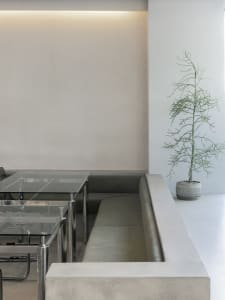 Empty room with a white wall and a green couch, two chairs, and a calm atmosphere