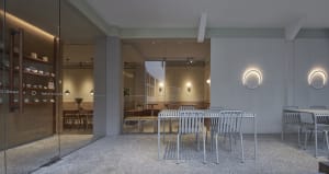 Dining area with multiple tables and chairs, featuring a large table and a smaller table, in a restaurant or café setting