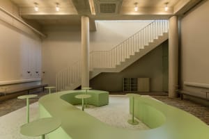 A modern staircase with concrete steps and a metal railing, set against a bright and airy background