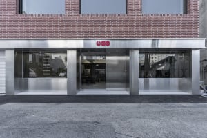 A contemporary building with a metal door and brick facade, set against a bright and sunny background
