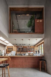 Cozy cafe with a wooden countertop, chairs, stools, and multiple cups, creating a warm and inviting atmosphere
