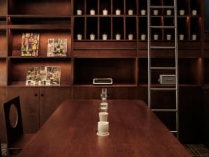 A home office with a wooden table, chair, and scattered books, conveying a sense of organization and functionality
