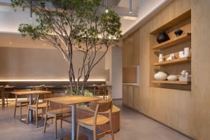 Warm and inviting restaurant interior with wooden walls and floors, dining tables, chairs, and decorative vases