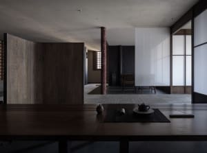 Empty modern living room with wooden floors and walls, featuring a dining table and two chairs