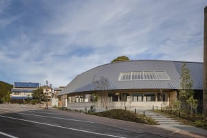 Modern building with a curved roof, brick and metal exterior, and large windows providing natural light