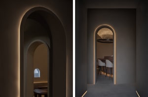 Dimly lit restaurant with stone walls, chairs, and dining tables