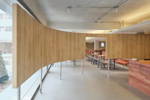 Empty restaurant with wooden walls and floors, featuring chairs placed throughout the dining area in a clean and inviting atmosphere