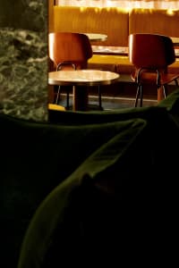 A modern restaurant interior with multiple dining tables and chairs, creating an inviting atmosphere for guests