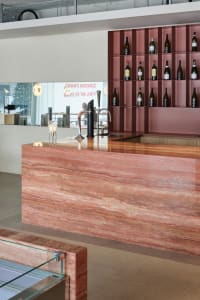 A sophisticated bar area with a marble countertop, wine rack, and wine glasses, creating a luxurious atmosphere for socializing