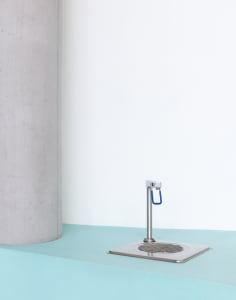 A clean and organized bathroom with a white sink and countertop, featuring a silver faucet and drain, against a wall