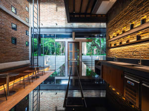 Open living area with brick walls, modern furniture, and a potted plant, featuring a bright and inviting atmosphere with ample seating options
