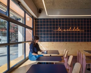 Comfortable cafe with chairs and tables, a woman sitting at one, and a warm atmosphere