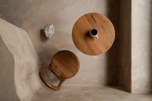 A cozy living space with a wooden dining table, two chairs, and a rock, creating a warm atmosphere for gathering and conversation