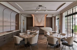 Warm and inviting restaurant interior with wooden floors and walls, featuring dining tables, chairs, wine glasses, and bottles