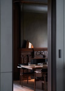 A warm and inviting dining area with a wooden table surrounded by chairs, set for a meal with multiple cups and a cozy atmosphere