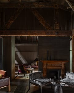 Inviting living area with a fireplace, couches, chairs, and a dining table, featuring various decorative elements and a warm atmosphere