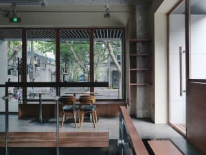 Modern restaurant interior with wooden floors and walls, comfortable seating areas, and ample space for guests