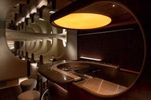 A warm and inviting restaurant bar with a counter and stools, surrounded by chairs and a comfortable atmosphere