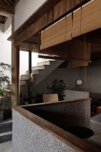 Cozy home interior with a staircase, two chairs, a potted plant, and a vase, featuring a warm and inviting atmosphere