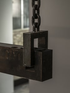Exposed metal structure with a chain hanging from the ceiling, featuring a mix of industrial and antique elements