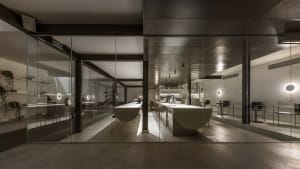 Industrial kitchen with white countertops, multiple dining tables, and various appliances, set in a clean and organized space